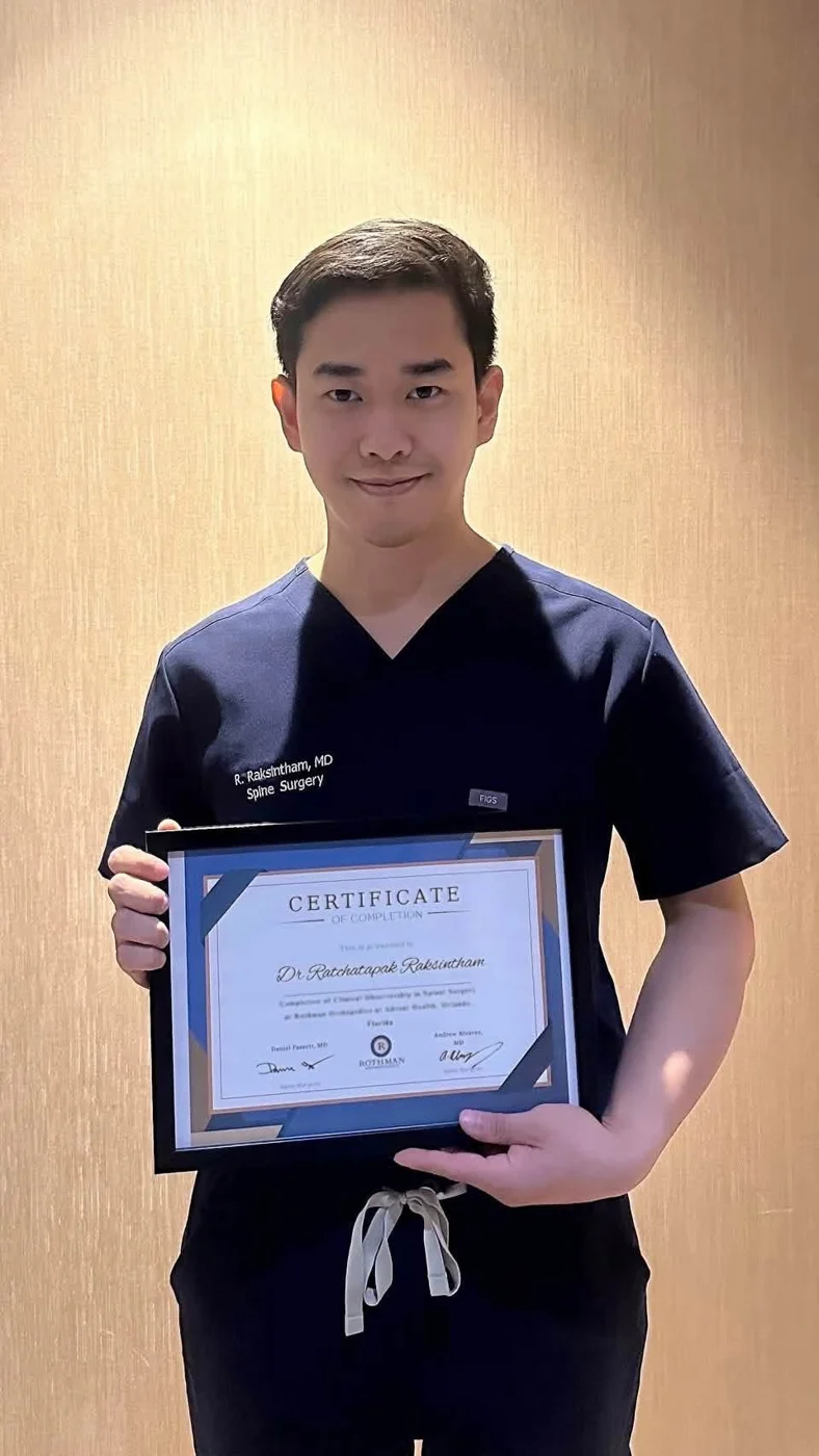 Dr. Ratchatapak holding a training certificate in the USA